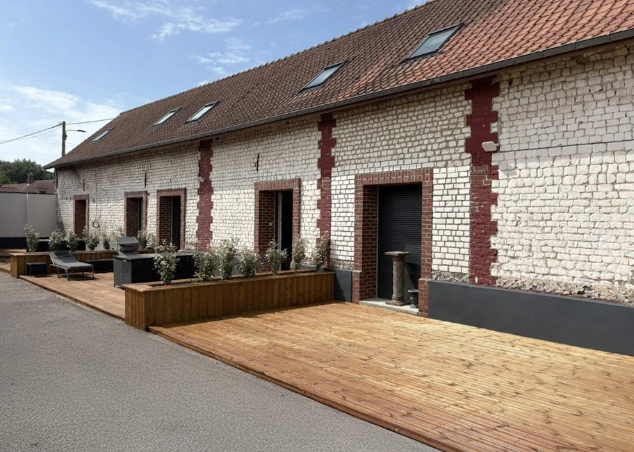 Façade extérieure de bâtiment rénové avec terrasse en bois